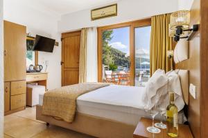 a hotel room with a bed and a balcony at Blue Green Bay in Panormos Skopelos