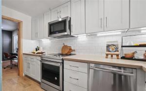 a kitchen with white cabinets and a stove top oven at Waterfront Three-Bedroom Condo with Great Views in Naples