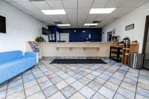 a waiting room with a couch and a counter at Budget Inn Greenville By Hotel O I-85 in Greenville