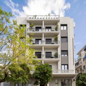 an apartment building with balconies and trees at The First by 22 in Piraeus