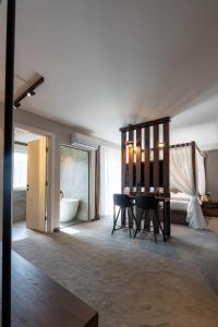 a room with a table and a bed and a bathroom at Five Apartments in Pristina