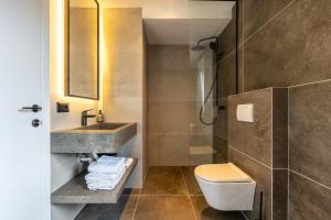 a bathroom with a sink and a toilet and a shower at Five Apartments in Pristina