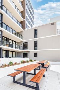 a group of picnic tables in front of a building at 412 on CODA Oasis with Mountain View in Coffs Harbour