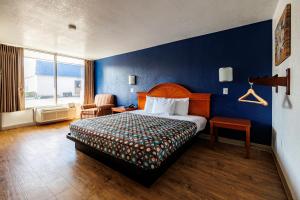 a hotel room with a bed and a blue wall at Budget Inn Greenville By Hotel O I-85 in Greenville +22 photos