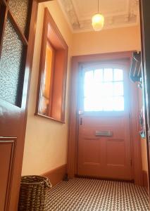 a hallway with a red door and a window at Artists Seaside Sanctuary in St. Leonards