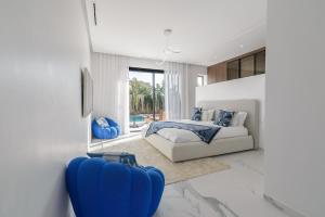 a bedroom with a bed and a blue suitcase at Villa Sofya - Roche Bobois Design & HD Wifi in Marrakesh +35 photos
