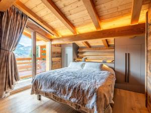 ein Schlafzimmer mit einem Bett und einem großen Fenster in der Unterkunft Chalet 5★, 10 pers, hammam, proche pistes, animaux admis - FR-1-304-297 in La Clusaz