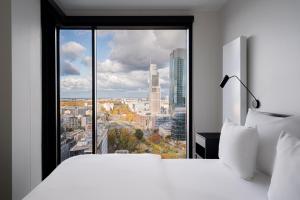 a bedroom with a large window with a city view at J&K Towarowa Towers in Warsaw