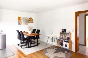 eine Küche und ein Esszimmer mit Tisch und Stühlen in der Unterkunft Ferienwohnung Kleiner Fuchs - für Familien mit Babys eingerichtet in Höchenschwand