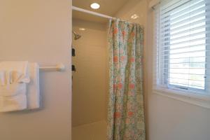 a bathroom with a shower curtain and a window at Madelyn's Oceanview in Tybee Island +21 photos