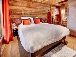 a bedroom with a large bed in a wooden room at Chalet luxe 5*, 9 pers, spa, vue montagnes - FR-1-304-310 in La Clusaz