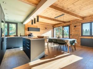 una cucina con pareti in legno e tavolo con sedie di Chalet 8 pers avec SPA, proche pistes, rénové, WIFI, garage - FR-1-304-285 a La Clusaz