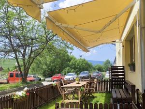 a patio with a table and chairs under a yellow umbrella at The Other House in Miercurea-Ciuc