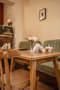 a wooden table with a vase of flowers on it at La Noire Petit hotel in Buenos Aires