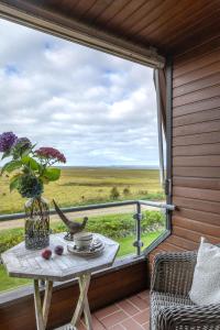 une table avec un vase de fleurs sur un balcon dans l'établissement Luxus Heefwai, à Morsum
