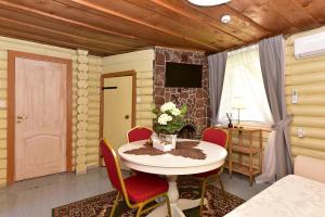 a dining room with a table and chairs and a television at Bražuolėje Pas Juozą- ramiam poilsiui in Trakai