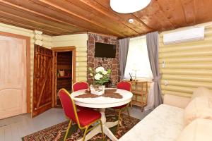 a dining room with a table and chairs and a tv at Bražuolėje Pas Juozą- ramiam poilsiui in Trakai