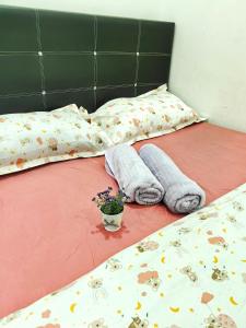 deux lits avec des couvertures et une plante en pot dessus dans l'établissement Fun Fun Stay Tangkak by GX Homestay, à Tangkak