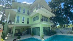 a house with a swimming pool in front of it at Green orchid Apartment in Mae Nam