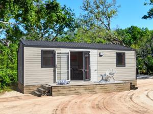 a small shed with a porch on a dirt road at Camping Le Royan in Royan