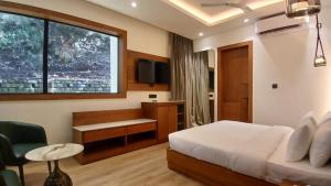 une chambre avec un lit, un bureau et une fenêtre dans l'établissement Lawrence Tungsten Resort, à Nainital