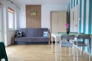 a living room with a table and a couch at Apartamenty Poddąbek- basen kryty, sauna, animacje dla dzieci , małpi gaj, baseny na dachu in Poddąbie