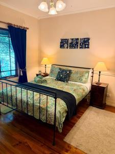 a bedroom with a bed and two lamps and a window at Korla Cottage, Leura Family & Pet Friendly Stay in Leura