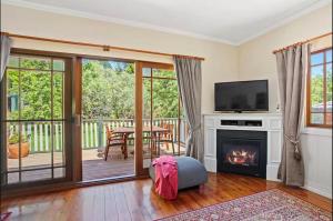 ein Wohnzimmer mit Kamin und Fernseher in der Unterkunft Korla Cottage, Leura Family & Pet Friendly Stay in Leura