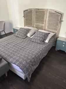 een slaapkamer met een bed met een houten hoofdeinde en kussens bij Chambres d'Hôtes Le Felseneck in Ferrette +39 foto's