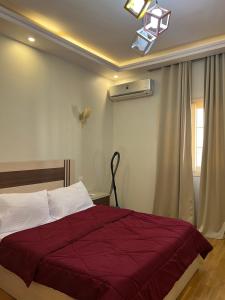 a bedroom with a bed with a red blanket at The Royal Apartment at New Cairo in Cairo