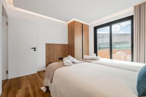 Dos camas en un dormitorio con una gran ventana. en Golden Home IV, en Caniçal 20 fotos más