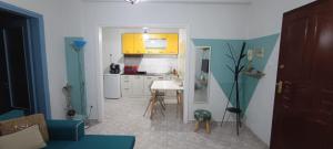 una cocina con armarios amarillos y una mesa en una habitación en Blue dream, en Komotiní 10 fotos más