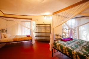 a bedroom with two beds and a window at Octagon Lodge in Karatu +90 photos