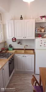 Una cocina con gabinetes blancos y un fregadero. en Il rifugio di Francesca, en Cisternino