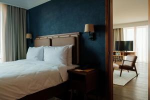 a bedroom with a bed with a blue wall at BODBE Hotel in Sighnaghi