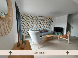 a living room with a couch and a tv at La truffière des Collines - Côté Tilleul in Génissieux