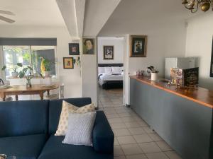 a living room with a blue couch and a kitchen at Strand Stay Cottage in Strand