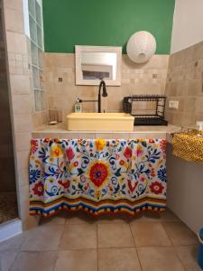 a bathroom with a sink and a counter with a flower pattern at Gîte dans La circulade - Le Pouget in Le Pouget +19 photos