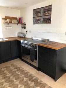 a kitchen with a stove and a counter top at Raven Cottage in Rhiconich