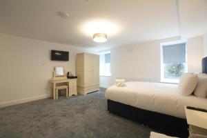 a bedroom with a bed and a cabinet and a desk at The Lodge in Dunmore