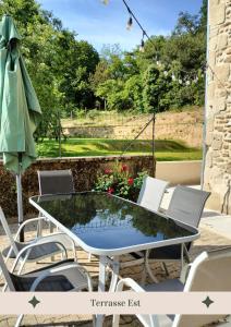 a glass table and chairs on a patio at La truffière des Collines - Côté Tilleul in Génissieux