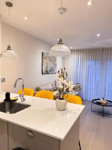 a kitchen and living room with yellow chairs at Spacious 4-Bedroom House Ideal for Contractors, Families & Business Stays in Reading, Offers 3 Parkings in Burghfield +38 photos