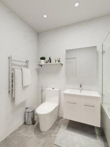 a white bathroom with a toilet and a sink at Nomads Nook in London