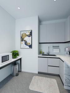 a white kitchen with a sink and a microwave at Nomads Nook in London