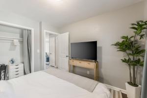 Apartment Kansas City 15mins to KCI with a KING bed and work desk في Riverside: غرفة نوم مع سرير وتلفزيون بشاشة مسطحة
