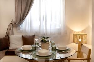 a dining room table with plates and dishes on it at The PINE - Stylish city apartment Comfort and Cosiness for 4 in Thessaloniki
