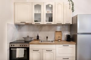 a kitchen with white cabinets and a sink at The PINE - Stylish city apartment Comfort and Cosiness for 4 in Thessaloniki