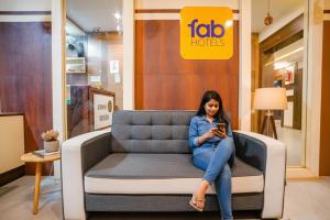 a woman sitting on a couch in a store at FabExpress Diamond - Nr BKC in Mumbai