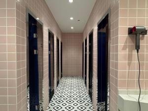 pasillo de un baño con azulejos blancos y negros en Third Floor Youth Hostel, en Shanghái