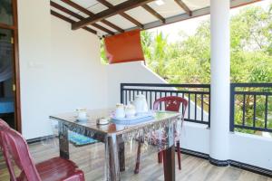 ein Glastisch und Stühle auf einer Veranda mit Balkon in der Unterkunft Amible Guest Home in Mirissa + 70 Fotos